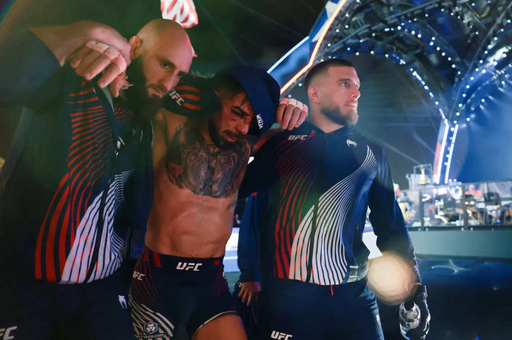Ilia Topuria được anh trai dìu rời khỏi khu vực thi đấu sau trận thua tại UFC Freedom 250